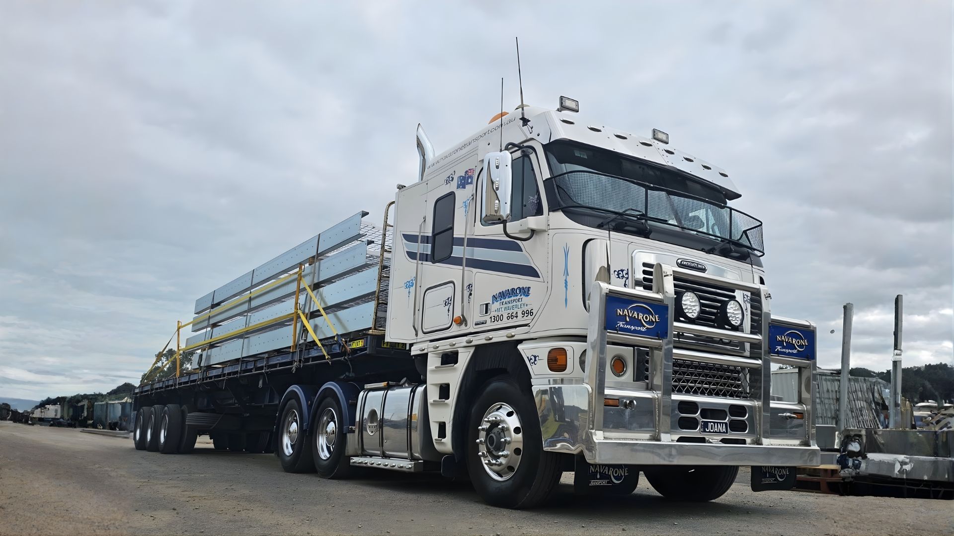 Navarone truck carrying a big yellow piece of machinery