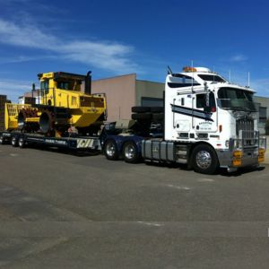 truck carrying a large piece of machinery